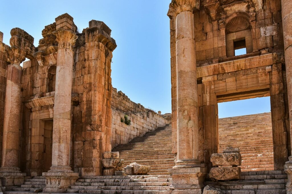 Ancient stone columns and archways frame a monumental staircase at the historic Petra archaeological site.