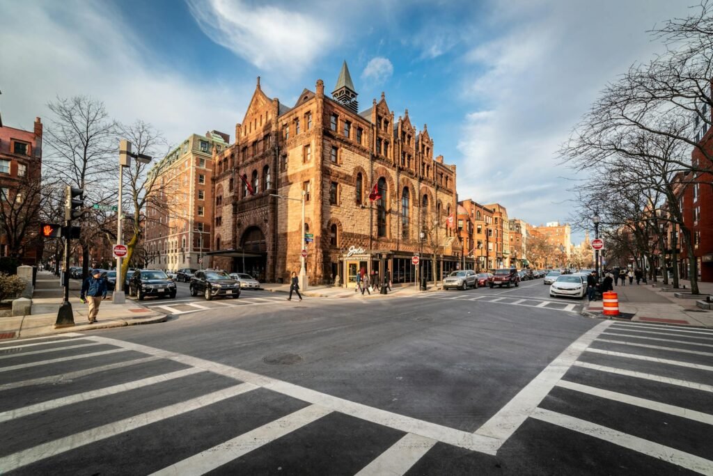 Historic castle-like building with stone facade at busy intersection in downtown Boston.