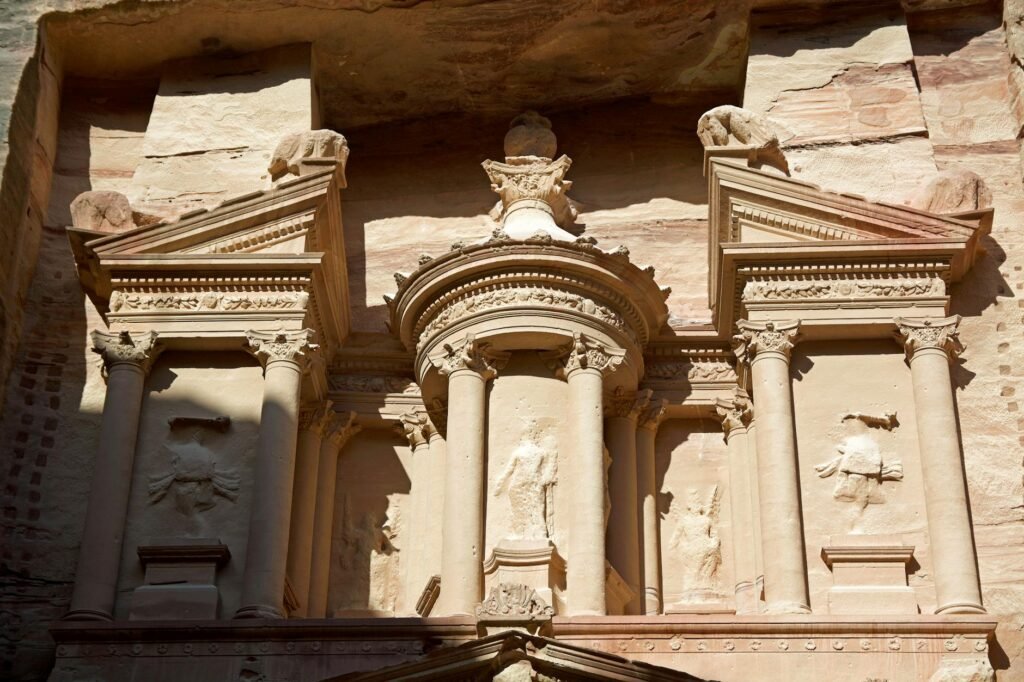 Ancient carved stone facade with ornate columns and decorative architectural details at Petra.
